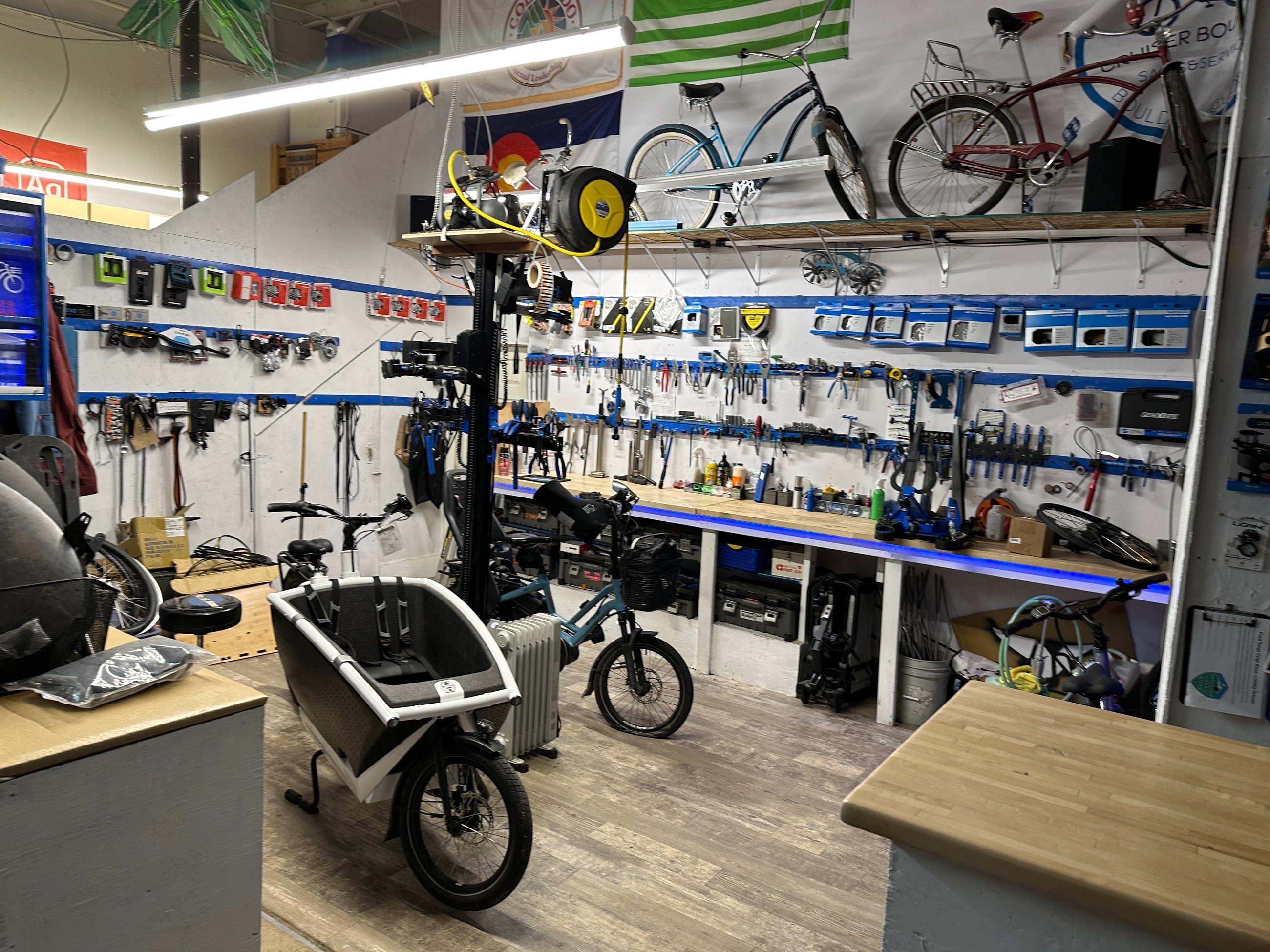 The service bench at the shop, tools on the wall and a cargo bike on the floor